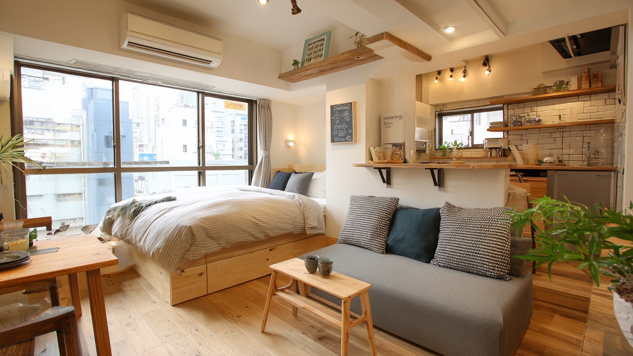 Modern Japon stüdyosu iç mekanı, kompakt yatak ve oturma alanı, doğal ışık ve küçük mutfak ile minimalist ve fonksiyonel yaşam alanı